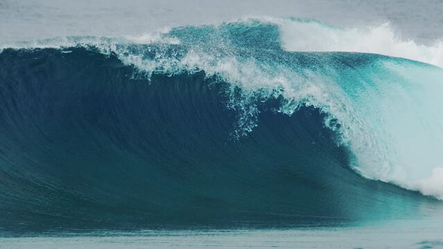 Big ocean wave rolls and breaks in the Maldives