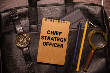 On the table are financial reports, a pen, a magnifying glass and a notebook with the inscription - CSO. Chief Strategy Officer.