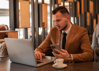 Young business man working on a laptop at cafe restaurant or office.