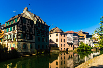 Fototapeta na wymiar Charming view of residential half-timbered buildings along canals of Strasbourg.