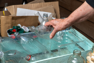 Elderly woman sorting recyclables in home recycling bins.