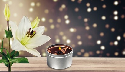 White lilies flowers and burning candle - obrazy, fototapety, plakaty