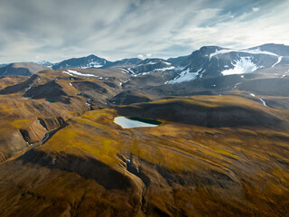 drone shot for breathtaking footage of wild nature in svalbard, majestic mountains in the clouds, massive river and nature under the cloud, useful for newspapers and magazines, travel to unspoiled 