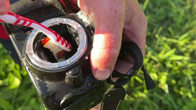Camera sensor cleaning (CCD or Cmos). Photographer cleaning photocamera light sensor, maintaining the mirrorless. Cleaning matrix SLR camera with water. Clean Lens of camera. Professional photographer