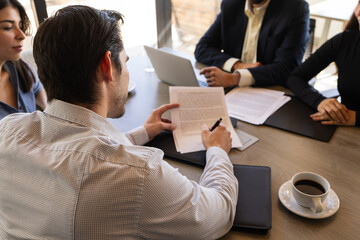 Rear view of a businessman signing a contract in a meeting room