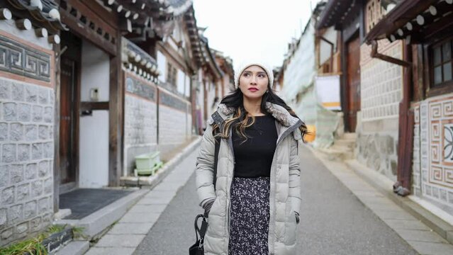 Slow-motion video of a young Filipino woman in her 20s taking a walk in Hanok Village, North Village, Seoul, Republic of Korea on a cold winter day 寒い冬の日に大韓民国ソウル北村韓屋村を散歩する20代の若いフィリピン人女性のスローモーションビデオ