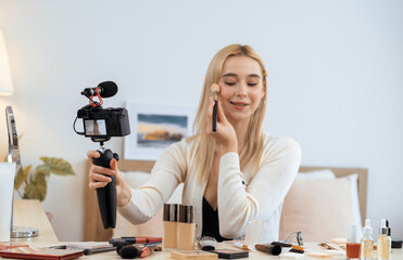 Young woman making beauty and cosmetic tutorial video content for social media. Beauty blogger...