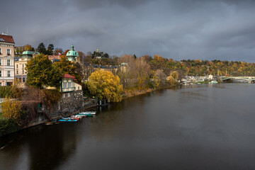 Fototapeta premium Autumn - the sunlit Prague embankment - a moment before the rain