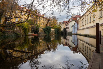 Fototapeta na wymiar autumn reflections on the Čertovka canal under the Charles Bridge
