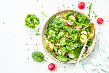 Green salad with spinach, arugula and radish with olive oil.