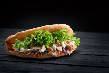 Doner kebab - fried chicken meat with vegetables in pita bread