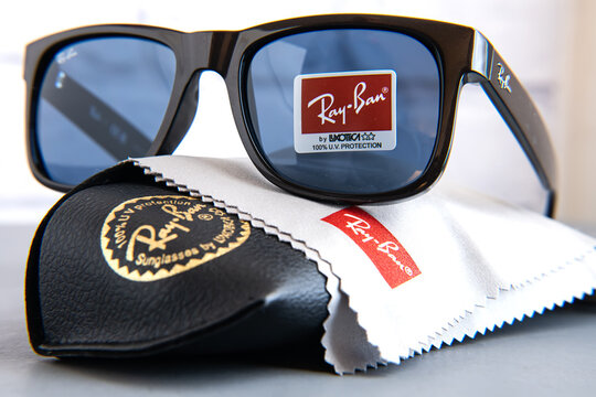 Ray-Ban sunglasses case with the company brand logo and Black Ray-Ban sunglasses with plastic frames.