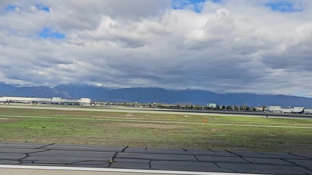 footage of the tarmac at the Ontario International Airport with planes and runways, blue sky and clouds in Ontario California USA