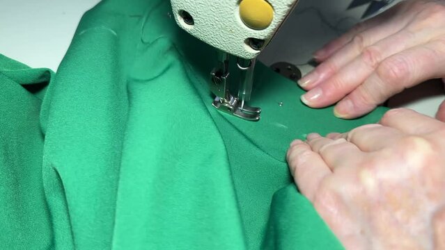 Untitled Sewing work. Stitching a hole in jeans with a sewing machine. Seamstress sews with jeans cloth. Darning jeans on a sewing machine. Seamstress sews on a sewing machine. Tailoring.