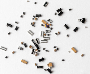 An array of various electronic components and microchips randomly scattered across a clean white surface.
