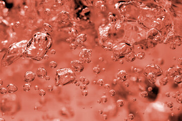 A close-up shot highlighting the intricate details and movement of effervescent bubbles suspended in a fluid with a warm color palette.