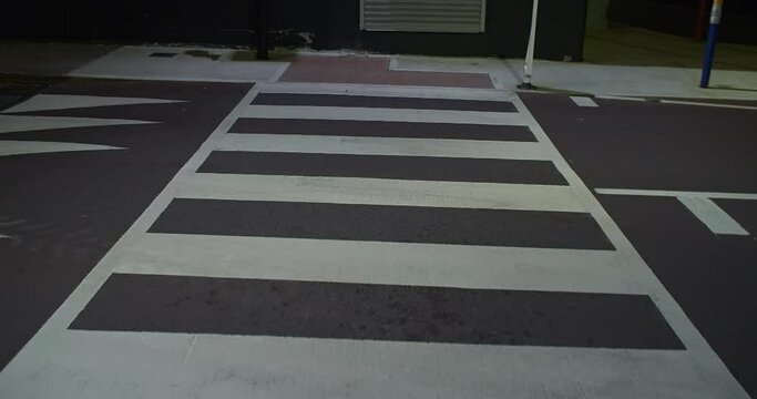 Pedestrian zebra road crossing at night walking point of view stabilized