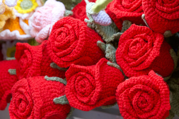 Obraz na płótnie Canvas Close up on hand crafted crochet vibrant red rose flowers