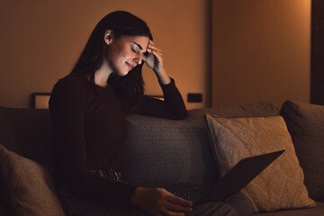 Stressed woman at late night having strong terrible headache attack after computer laptop study,...