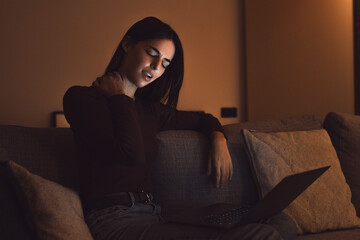 Fototapeta premium Stressed woman at late night having strong terrible neckache attack after computer laptop study, sleepy exhausted girl suffering from chronic migraine massaging muscle to relieve neck ache tension.