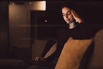 Stressed woman at late night having strong terrible headache attack after computer laptop study,...