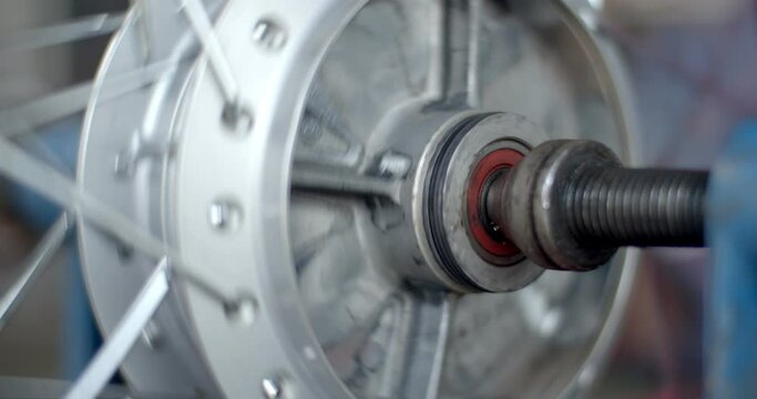 Close up wheel bearing and hub wheel.motorcycle mechanic using a wrench and socket Adjustment of a motorcycle rim.