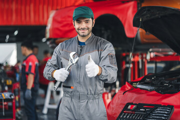 Portrait happy automobile mechanic man showing thumbs up looking at camera and smile. diagnostic and repairing vehicle at garage automotive, Car care check and fixed and services insurance concept.