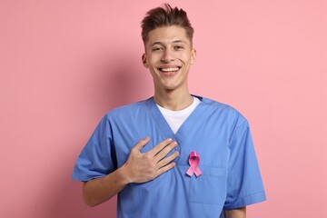 Mammologist with pink ribbon on color background. Breast cancer awareness