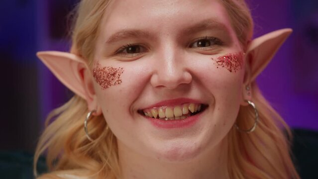 Woman elf portrait. Young female person wearing elves ears costume. Teenager smiling and posing. Party people, holiday. 