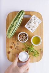 Cucumber Salad with White Cheese and Nuts Ingredients on a wooden chopping board and white background