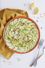 Cucumber Salad with White Cheese and Nuts Ingredients on a wooden chopping board and white background