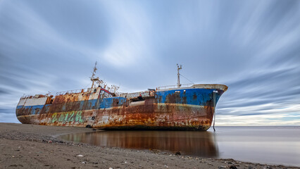 Abandoned Shipwreck on a Peaceful Shoreline at Dusk