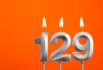 Candle number 129 - Birthday in orange background