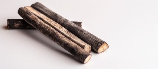 A collection of wooden sticks neatly stacked on top of a flat table surface. The sticks vary in length and thickness, creating an organized pile.