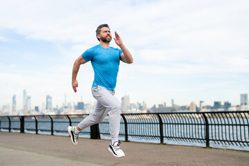Man runner in sport outfit run in NYC. Motion, healthy run. Mature jogger run near Manhattan downtown. Muscular athlete sportsman run in city. Running sportswear. Handsome guy running workout outdoor.