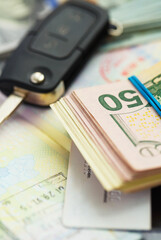 American money, credit cards and car key lies on thr top of the opened passport