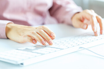 Woman office worker typing on the keyboard