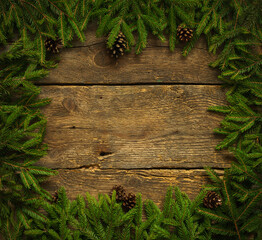 Christmas tree branches with cones on wooden texture ready for your design