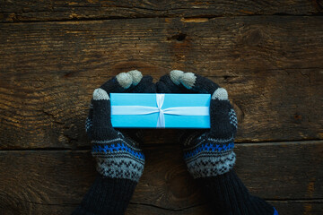 Hands in winter gloves with christmas gift box