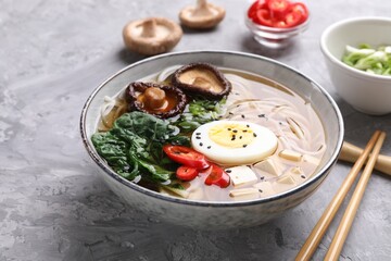Delicious vegetarian ramen served on grey table, closeup. Noodle soup