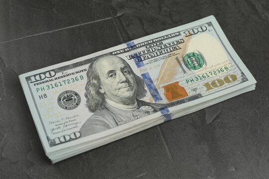 Money exchange. Dollar banknotes on dark gray textured background, closeup