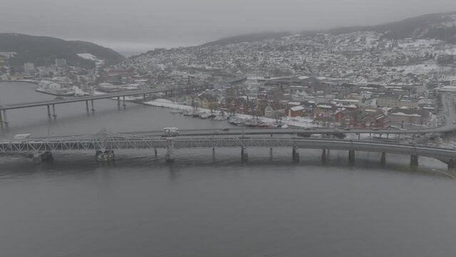 Drone video of Drammen city in Norway during winter. River and railway on a cloudy day.