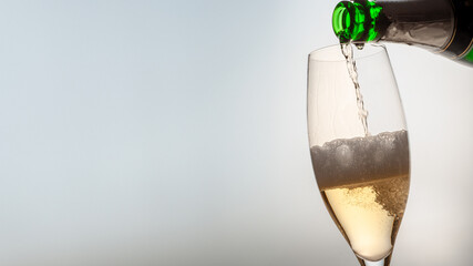 champagne is poured into a glass with free space for text