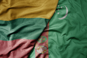 big waving national colorful flag of turkmenistan and national flag of lithuania .