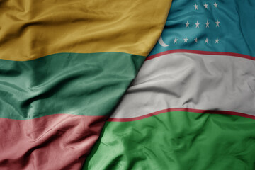 big waving national colorful flag of uzbekistan and national flag of lithuania .