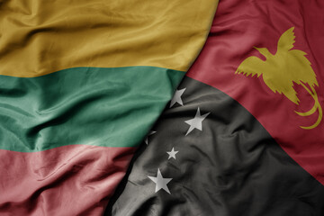 big waving national colorful flag of Papua New Guinea and national flag of lithuania .