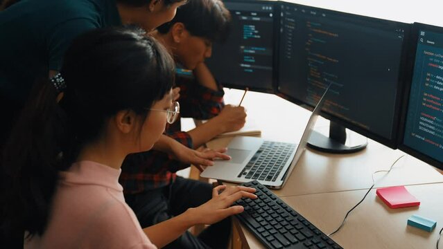 Slow motion back end software developer engineer for computer programming working together on debugging writing computing code, solving complex algorithms display on monitor in office. Burgeoning