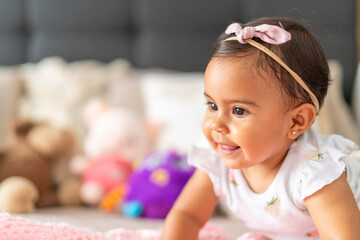 Obraz premium Cheerful Baby Girl with Headband Crawling on Blanket