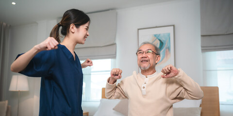 Fototapeta premium Young asian female nurse care giver helping asian senior old man in living area of nursing home senior daycare center, Nurse take care elderly patient with cheerful concentrate, health insurance