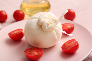 Plate with tasty Burrata cheese on table